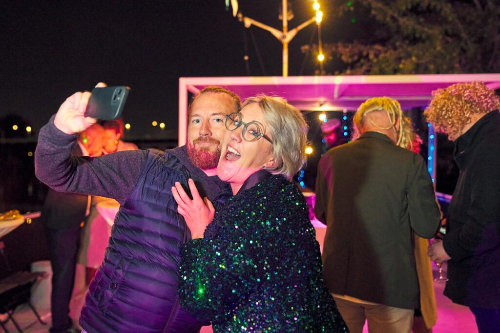 Photographe Soirée d'Entreprise : Les invités font un selfie avec Clémence sur la péniche pour la soirée des 10 ans de France Inertage - Triel-sur-Seine, Yvelines - © Laurent Delisle